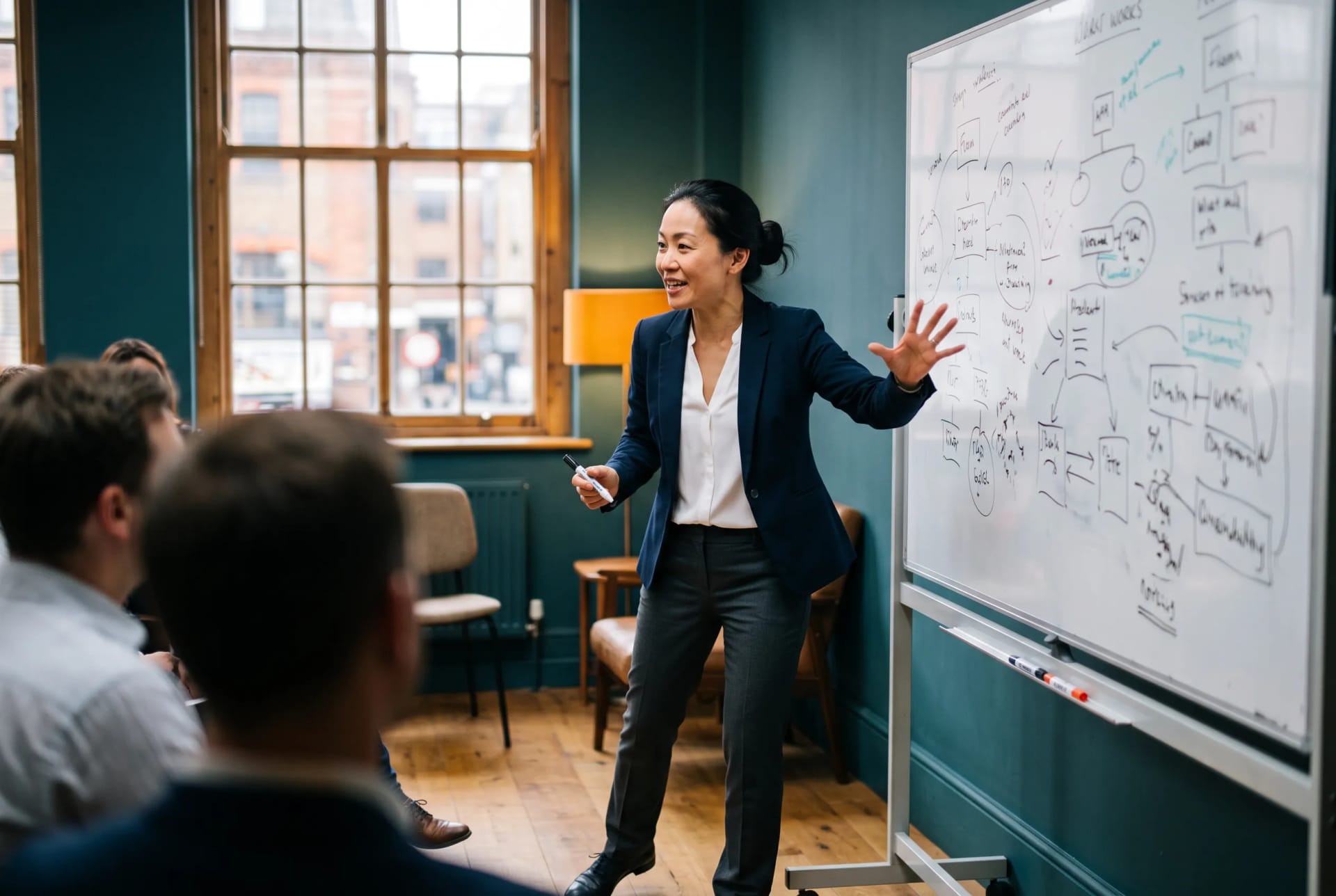 A person standing at a whiteboard mid-gesture, presenting with energy